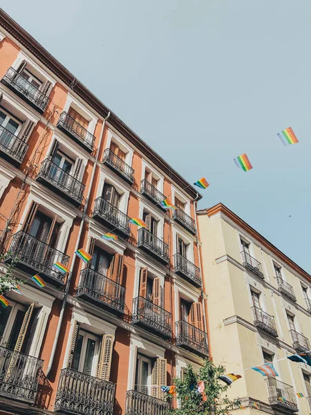 Arco iris bandera LGBT contra cielo azul en la ciudad de Madrid — Foto de Stock