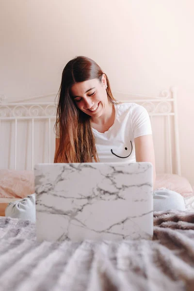 beautiful feminist woman with breasts drawn on t-shirt smiling and writing on laptop