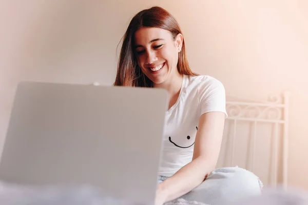 สาวสวยยิ้มและเขียนบนแล็ปท็อปของเธอ — ภาพถ่ายสต็อก