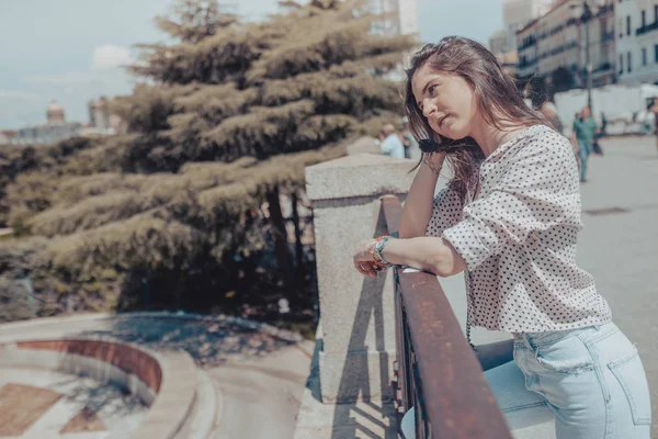 Belle jeune femme reposant sur une balustrade près du Palais Royal de Madrid, Espagne Image En Vente