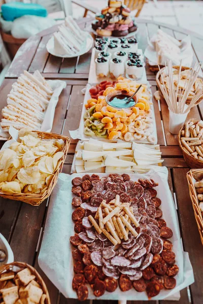 Antipasti and fruit concept. Tasting gourmet party on a rustic wooden table. A quick and easy snack for party time. Rustic style. Stock Photo