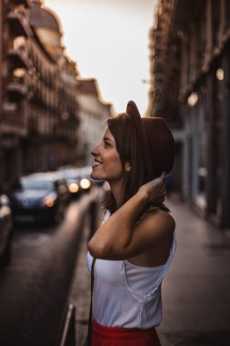 Madrid, Ispanya 'da günbatımı bir sokakta Turizm zevk şapka ile genç kadın