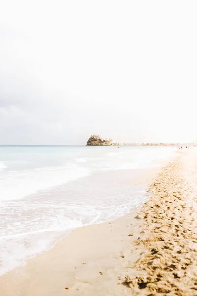 Beautiful views of the beach with the castle in the distance in Spain. Travel concept.