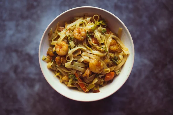 暗い背景に野菜とエビと麺のボウル。アジア料理のコンセプト。トップビュー — ストック写真