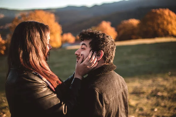 Casal apaixonado acariciando no outono na floresta outonal, desfrutando de um belo dia. Casal beijando no colorido parque laranja e amarelo . — Fotografia de Stock