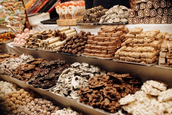 Enfant pointant des bonbons et des chocolats au marché de Noël à Budapest, Hongrie. Gros plan sur bonbons, chocolat & étal de massepain sur la boutique du marché, image de fond de foire ou d'exposition. Images De Stock Libres De Droits