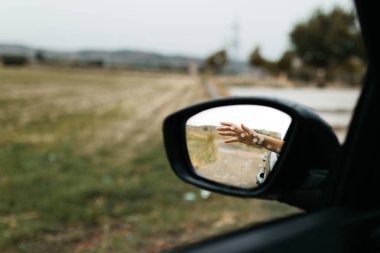 Yağmur damlalarına dokunmak. Camdan yansıyan ayna. Islak araba penceresi. Yağmur damlasını kapatın. Araba görüntüsü aynaya bak. Yağmurlu gün.