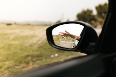Yağmur damlalarına dokunmak. Camdan yansıyan ayna. Islak araba penceresi. Yağmur damlasını kapatın. Araba görüntüsü aynaya bak. Yağmurlu gün.