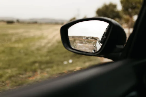 유리잔을 통해 볼 수있는 백미러. 젖은 차 창문. 빗방울을 닫습니다. 자동차의 모습 이 거울을 본다. — 스톡 사진