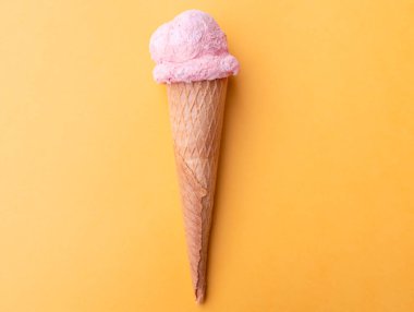 Çilekli dondurmayı turuncu arka planda waffle külahıyla kapat. Boşluğu kopyala.