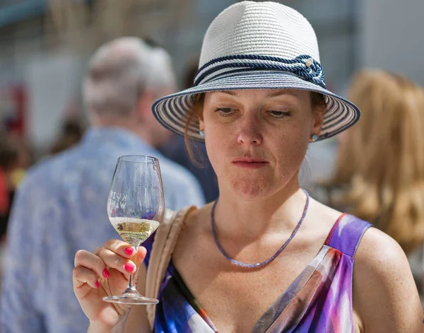 Kiev, Ukrayna - 2 Haziran 2018: Çiller şapkalı olan kadın Kiev Şarap Festivali beyaz şarap tadı. dünyanın dört bir yanından gelen 77 winemakers iyi şarap şirketi tarafından düzenlenen festival big aldı