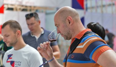 Kiev, Ukrayna - 02 Haziran 2018: Adam tadı kırmızı şarap Kiev Şarap Festivali orta yaşlı. dünyanın dört bir yanından gelen 77 winemakers iyi şarap şirketi tarafından düzenlenen festival big aldı.