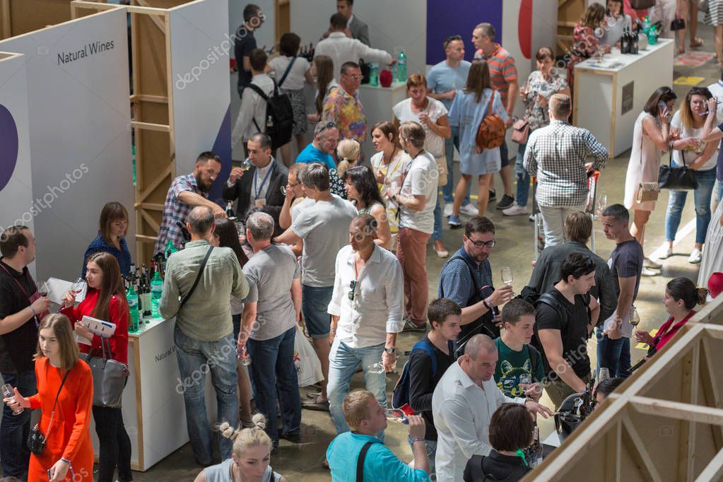 KIEV, UKRAINE - JUNE 02, 2018: People taste wine at Kyiv Wine Festival boothes. 77 winemakers from around the world took part in the big festival organized by Good Wine company.
