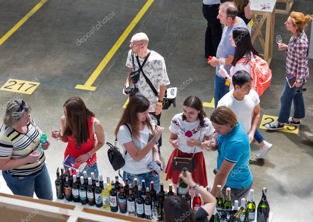 KIEV, UKRAINE - JUNE 02, 2018: People taste wine at Kyiv Wine Festival boothes. 77 winemakers from around the world took part in the big festival organized by Good Wine company.
