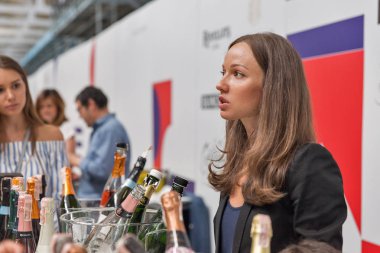 Kiev, Ukrayna - 02 Haziran 2018: Genç kadın sommelier Kiev Şarap Festivali standında onun köpüklü şarap sunuyor. dünyanın dört bir yanından gelen 77 winemakers iyi şarap şirketi tarafından düzenlenen festival bölümü big aldı.