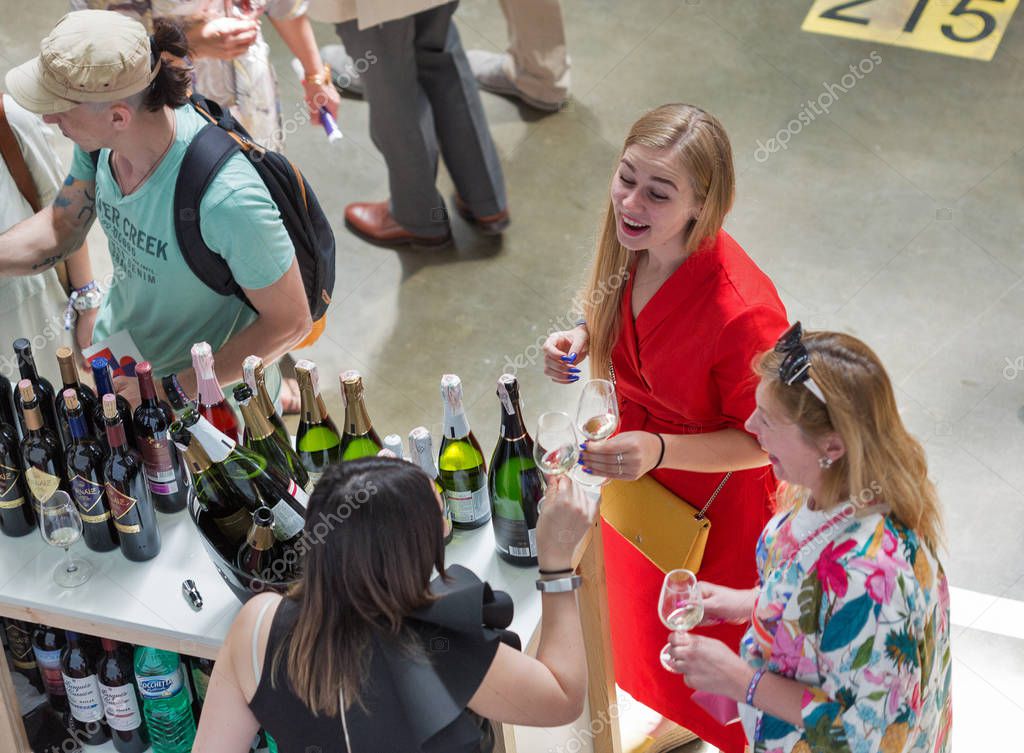 KIEV, UKRAINE - JUNE 02, 2018: People taste sparkling wine at Kyiv Wine Festival booth. 77 winemakers from around the world took part in the big festival organized by Good Wine company.