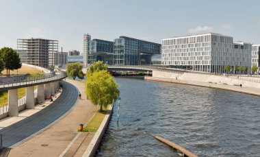 Berlin, Almanya - 13 Temmuz 2018: İnsanlar Berlin Hauptbahnhof merkez tren yolcu İstasyonu ve girişinde bir kanal ile Spree Nehri boyunca yürümek. Spree Berlin şehir merkezi üzerinden akar.