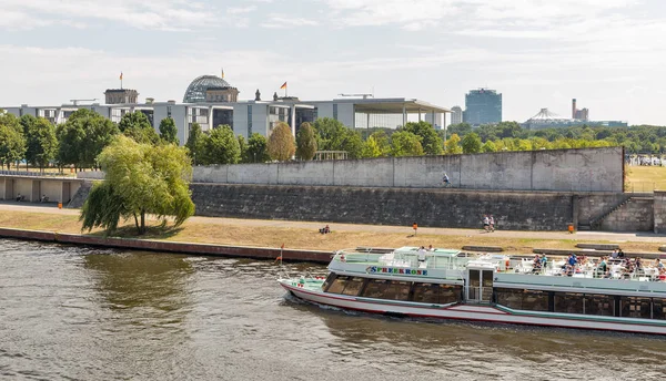 Berlin, Almanya - 13 Temmuz 2018: Spreekrone turistik gemi Mitte şehir bölgesinde arka planda Reichstag ve hükümet binaları ile bir sıcak yaz gününde Spree Nehri boyunca yelken yolcu.