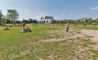 Berlin, Almanya - 13 Temmuz 2018: İnsanlar Reichstag veya Federal Meclisi önünde şehir merkezinde Cumhuriyet Meydanı Milli Park'ta çimenlerin üzerinde rahatlatıcı. Başkenti ve en büyük şehri Almanya Berlin olduğunu.