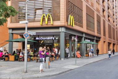 Berlin, Almanya - 13 Temmuz 2018: İnsanlar Mcdonald's Restoran şehir merkezinde gıda tadını çıkarın. Richard ve Maurice Mcdonald tarafından işletilen bir restoran olarak 1940 yılında kurulan bir Amerikan fast food şirketi.
