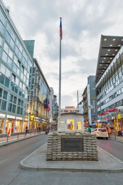 Berlin, Almanya - 13 Temmuz 2018: İnsanlar günbatımında bize ordu Checkpoint Charlie yürümek. Adı Berlin Duvarı geçiş noktası Doğu ve Batı Berlin arasında soğuk savaş sırasında verildi.