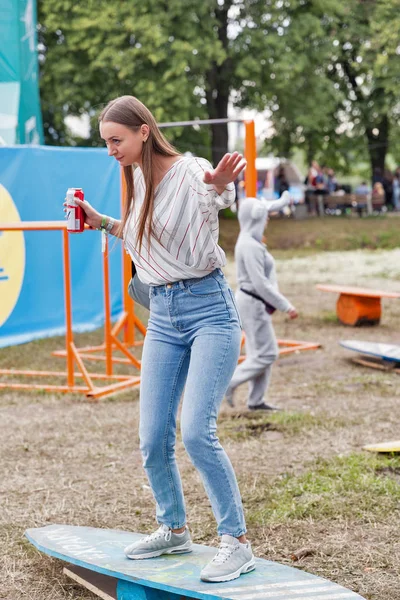 キエフ ウクライナ 2018 バドワイザー ビールの夏服は木製ウェイク ボードでアトラス週末祭国立エキスポ センターで屋外の楽しい時を過すに身を包んだ若い美しい笑顔の女性 — ストック写真