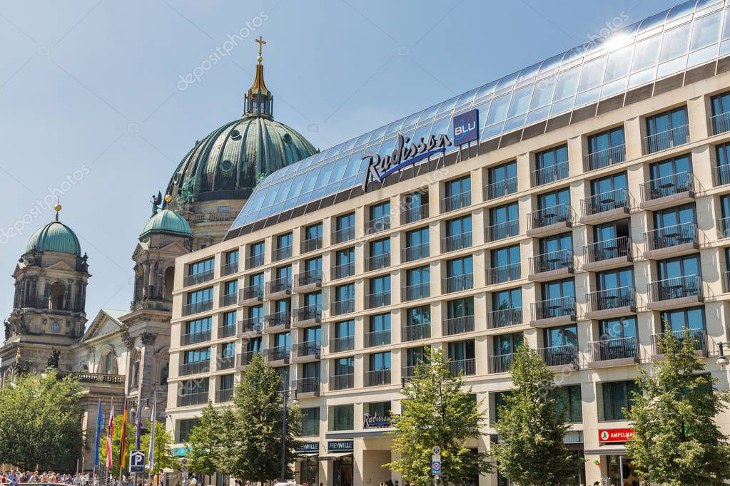 BERLIN, GERMANY - JULY 14, 2018: Radisson Blu hotel facade and Berliner Dome Cathedral in the background. Berlin is the capital and German largest city.