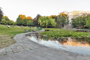 Berlin, Almanya - 14 Temmuz 2018: İnsanlar yakın küçük göl günbatımı City Volkspark bağında dinlen. Berlin Almanya en büyük şehir alanı ve nüfus başkentidir.