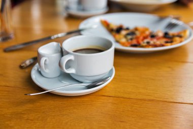 Kahve fincanı süt ve pizza ahşap masa portre üzerinde