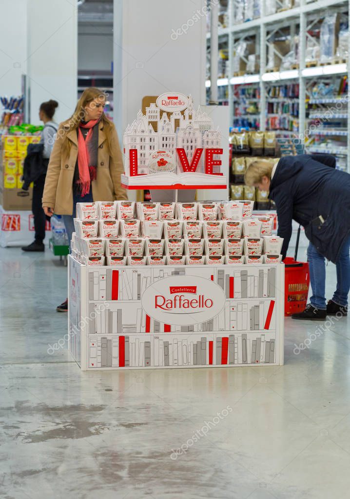 KIEV, UKRAINE - OCTOBER 18, 2017: People visit supermarket with Raffaello Confetteria booth. Raffaello is a spherical coconut almond confection that manufactured by Ferrero.