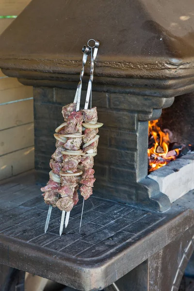 生肉和洋葱烤肉串串附近的烧烤室内 — 图库照片
