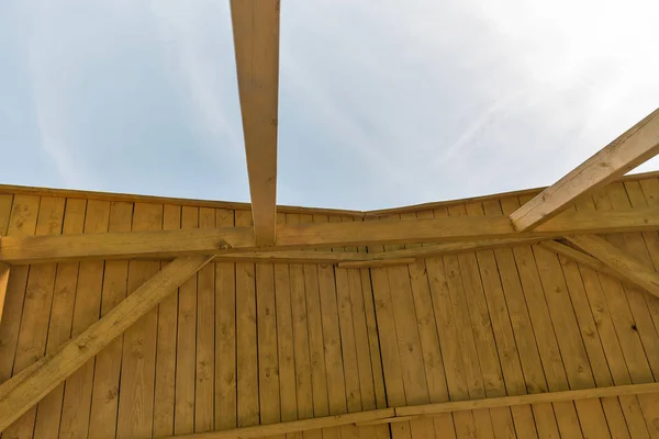 Görünümü bir eğimli çatı ve açık mavi gökyüzü İnşaat — Stok fotoğraf