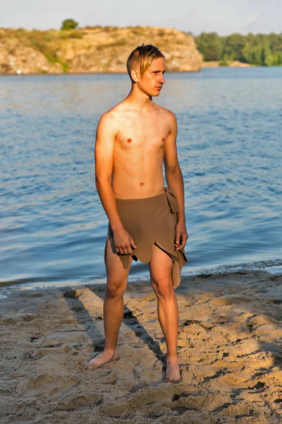 Guy in loincloth on the background of river beach — Stock Photo, Image