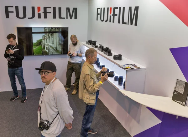Lidé testování profesionálních fotografických kamer v Fujifilm Booth. Kyjev, Ukrajina. — Stock fotografie