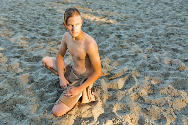 Kerel in lendendoek op de achtergrond van zand — Stockfoto