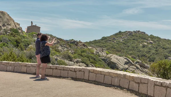 İnsanlar Roccapina sahilinin akıllı telefon fotoğraflarını çekiyor. Korsika, Fransa.