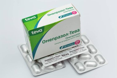 KYIV, UKRAINE - 28 Mayıs 2020: Gastroenteroloji jenerik ilaç Omeprazole by TEVA, box and su toplayıcıları beyaza yakın çekim. Teva Pharmaceuticals, ABD 'li bir İsrail firması.