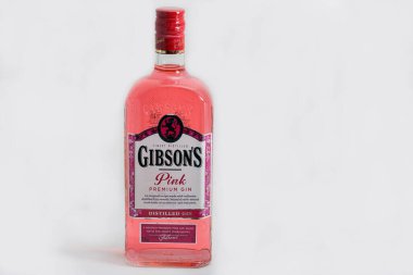 KYIV, UKRAINE - 28 Mart 2020: beyaz arka plana karşı Gibson 's premium pembe cin şişesi yakın plan. Cin, en çok ardıç meyvelerinden elde edilen alkollü bir içecektir..
