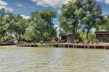 Ukrayna 'nın Vilkove kentindeki turistik bir tesiste dinlenmek ve balık tutmak için rahat yerleri olan Tuna Nehri ahşap rıhtımı..