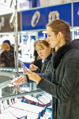 KYIV, UKRAINE - 18 Aralık 2015: KyivvvExpoPlaza Sergisi 'ndeki Noel Kuyumcusu Fuarı sırasında insanlar mücevher standını ziyaret ediyor.