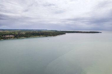 Hırvatistan 'ın Istria kentindeki Istria kentindeki ormanlık Lanterna yarımadası tatil beldesinin, otelleri ve eğlence tesisleri olan Adriyatik sularıyla çevrili insansız hava aracı manzarası.