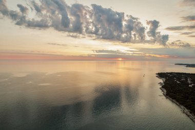 Hırvatistan 'ın Istria kıyısında, sakin Adriyatik Denizi üzerindeki dramatik akşam bulutları, sudaki yumuşak yansımalarla.