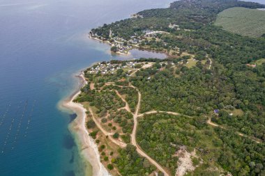 Hırvatistan 'daki Lanterna Istria yarımadasının yeşil ormanları, kıyı tatil beldeleri ve mavi Adriyatik sularının yer aldığı panorama hava aracı görüntüsü.