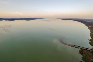 Balatonmariafurdo, Macaristan 'da canlı turuncu ve sarı gökyüzü ile Balaton Gölü üzerinde nefes kesici bir gün batımı. Marcali su deposundan kanal. Mükemmel altın saat ışıklandırması.