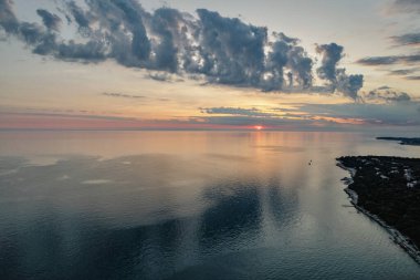 Hırvatistan 'ın Istria kıyısında, sakin Adriyatik Denizi üzerindeki dramatik akşam bulutları, sudaki yumuşak yansımalarla.