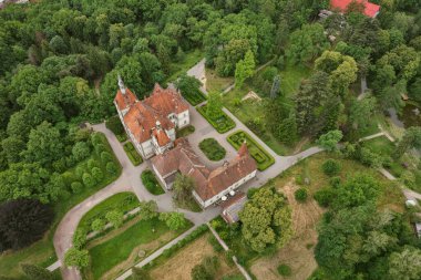 Ortaçağ Avrupa 'sındaki Kont Schonborn sarayının insansız hava aracı görüntüsünde kendine özgü terracotta fayans çatıları, taş kuleler ve yemyeşil ağaçlı barok mimarisi yer alıyor. Chynadiieve, Ukrayna.