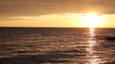 Sakin denizin üzerinde huzur dolu altın bir gün batımı. Su yüzeyine yansıyan titreşimlerle sakin ve sakin bir atmosfer yaratıyor. Rahatlama ve meditasyon için mükemmel. Istria, Hırvatistan.