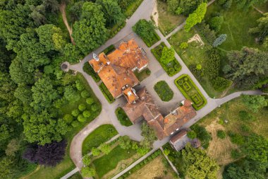 Ortaçağ Avrupa 'sındaki Kont Schonborn sarayının insansız hava aracı görüntüsünde kendine özgü terracotta fayans çatıları, taş kuleler ve yemyeşil ağaçlı barok mimarisi yer alıyor. Chynadiieve, Ukrayna.