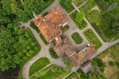 Ortaçağ Avrupa 'sındaki Kont Schonborn sarayının insansız hava aracı görüntüsünde kendine özgü terracotta fayans çatıları, taş kuleler ve yemyeşil ağaçlı barok mimarisi yer alıyor. Chynadiieve, Ukrayna.