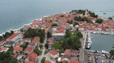 Hırvatistan 'ın Istria kentindeki ortaçağ kıyı kasabası Novigrad' ın çarpıcı hava aracı görüntüsü, kırmızı kiremitli çatılar, botlu marina ve güzel Adriyatik Denizi kıyı şeridini gösteriyor..